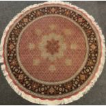 A Persian circular wool and silk rug, the central floral form medallion, enclosed within a