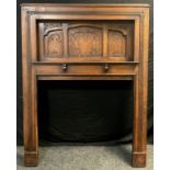 An early 20th century large oak fire surround/ Chimney-piece, recessed top with carved panels, and