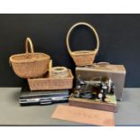 A vintage Singer hand operated sewing machine, cased with Singer Mat, wicker baskets etc