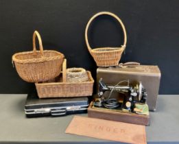 A vintage Singer hand operated sewing machine, cased with Singer Mat, wicker baskets etc