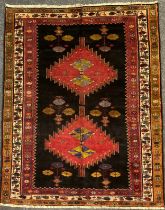 A North west Persian Heriz rug / carpet, hand-knotted in dark tones of red, blue, and green, on a