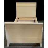 A single sleigh bed, in antique white painted finish, 95cm high x 209cm long x 97.5cm wide.