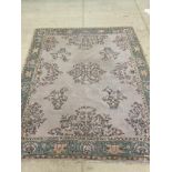 A large floral rug/carpet in tones of turquoise, yellow and cream, approx. 350cm x 280cm.