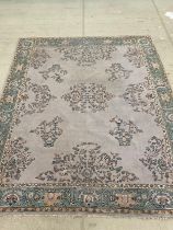 A large floral rug/carpet in tones of turquoise, yellow and cream, approx. 350cm x 280cm.