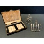 A cased pair of silver four division toast racks, Northern Goldsmiths Co, Birmingham 1933, 3.95ozt