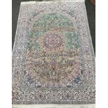 An Anatolian or Turkish woollen carpet, knotted in subdued tones of cream, blue, green, and grey,