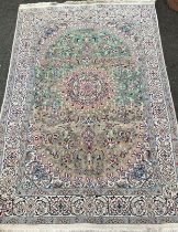 An Anatolian or Turkish woollen carpet, knotted in subdued tones of cream, blue, green, and grey,