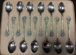 A set of twelve enamelled silver spoons, floral handles enamelled in blue, green yellow and white,