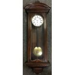 An oak cased Vienna wall clock, single weight Viennese movement, white enamelled dial with black