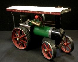 A Mamod TE1A Live Steam engine, green body, white canopy, rubber tracked rear wheels.