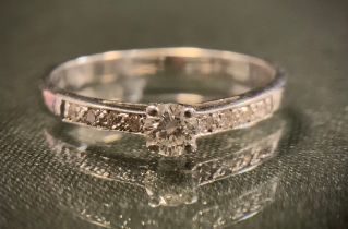 A diamond ring, principle round brilliant cut diamond approx 0.15ct, above diamond accented