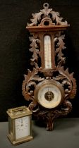 A carved oak Barometer, 49cm long; Brass carriage clock (2)