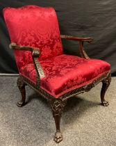 A late Victorian, 18th century style, carved walnut Library armchair, serpentine shaped back and