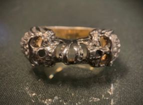 A Memento Mori style diamond skulls ring, the two facing skulls pave encrusted with rose cut