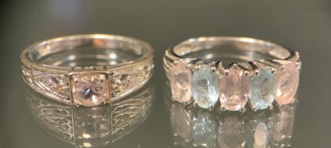 A diamond and morganite ring, central round pale morganite box claw set between diamond accented