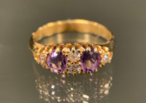 A late 19th /early 20th century diamond and amethyst ring, two pale purple amethysts divided by a