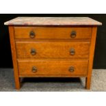 An early 20th century oak chest of drawers, over-sailing rouge marble top, three graduated long