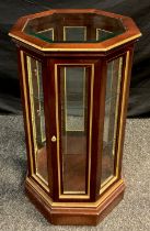 A mahogany octagonal-form Vitrine cabinet, floor-standing, glazed top and sides, two tiers of