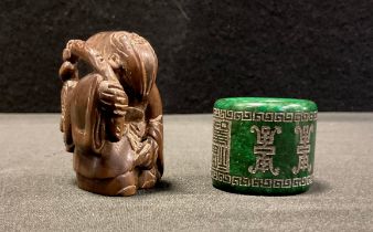 A carved wooden netsuke, as a bearded Elder, 5.2cm high, a carved green stone Archers ring, possibly