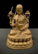 A gilt bronzed metal figure, Contemplating Buddhistic deity, in the lotus position, 23.5cm high.