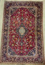 A Central Persian Kashan rug / carpet, knotted in rich tones of red, blue, deep indigo, green, and