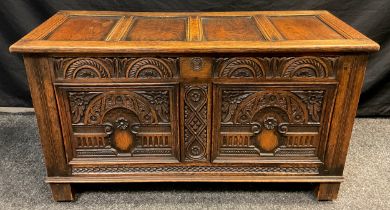 An 18th century style carved oak coffee / blanket chest, four-panel hinged top, carved front,