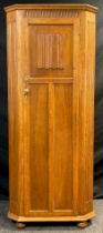 A mid 20th century oak hall robe, canted shaped front, single tall door with carved linen-fold