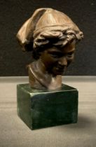 A bronzed metal bust, Boy with cloth cap, black stone plinth, 12.5cm high