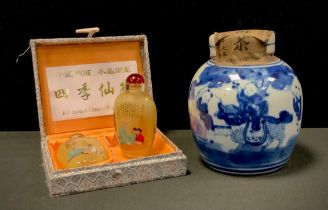 A Chinese blue and white tea jar and cover with paper seal; a pair of Chinese glass snuff bottles,