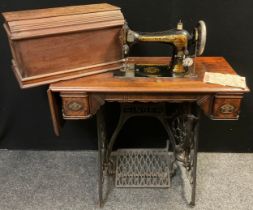 A Victorian Singer treadle sewing machine, no. 15388663, walnut table and case, cast iron treadle