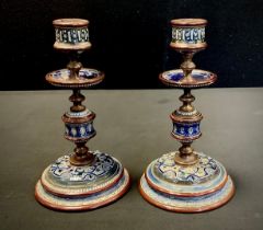 A near pair of Doulton Lambeth brass and earthenware candlesticks, relief decorated with scrolling