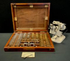 A John Trotter Opticians sight testing lens set, with brass and mixed metal mounts, mahogany case; a