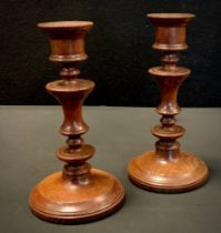 Treen - a pair of 19th century turned oak table candlesticks, 22.5cm high, (2).