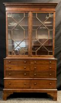 An early 20th century reproduction mahogany collector’s / library cabinet, out-swept dentil