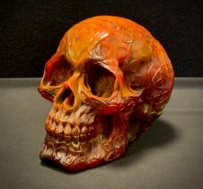 An amber coloured resin Skull, all over decorated with Celtic scrolls and motifs, 13cm high