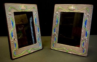 A pair of Art Nouveau style enamelled white metal photograph frames, stamped sterling, 19cm x 14.5cm