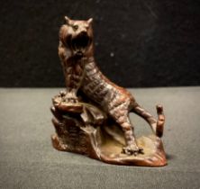 A small Japanese bronzed metal figure, as a Tiger climbing a Rock, 6cm high