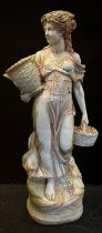 A glazed and painted figural statue, as a classical maiden, a planter basket to her arm, 136cm high