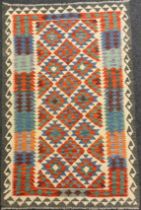 A Turkish Anatolian Kilim rug / carpet, knotted with geometric pattern in red, blue, green and grey,