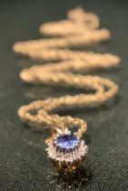 A diamond and tanzanite oval pendant necklace, oval tanzanite approx 0.30ct, surrounded by a halo of