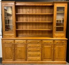 A large oak dresser, break-front centre top section, with out-swept cornice, above three tiers of