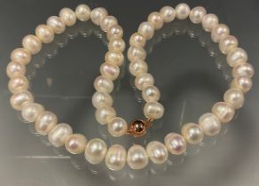 A single strand of large and heavy freshwater cultured pearls, of irregular creamy white colour,