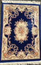A Chinese deep pile woollen rug / carpet, in deep blue, pink, and cream, 187cm x 126cm.