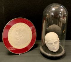 A classical style cast plaster head of a Spartan, displayed in a glass dome on ebonised base, 36cm