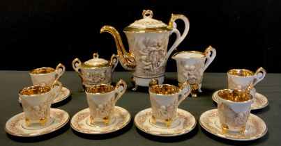 A Capodimonte coffee service for six, decorated with moulded cherubs including six cups and saucers,