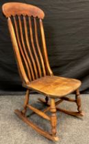 An early 20th century elm and beech lath-back rocking chair, 101cm high x 44cm wide x 55cm deep.