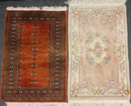 A Middle Eastern style rug in tones of umber, brown, and black, 153cm x 97cm; a Chinese rug, in soft
