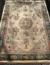 A Chinese deep pile woollen carpet, woven in tones of cream, pink, beige and green, 372cm x 278cm.