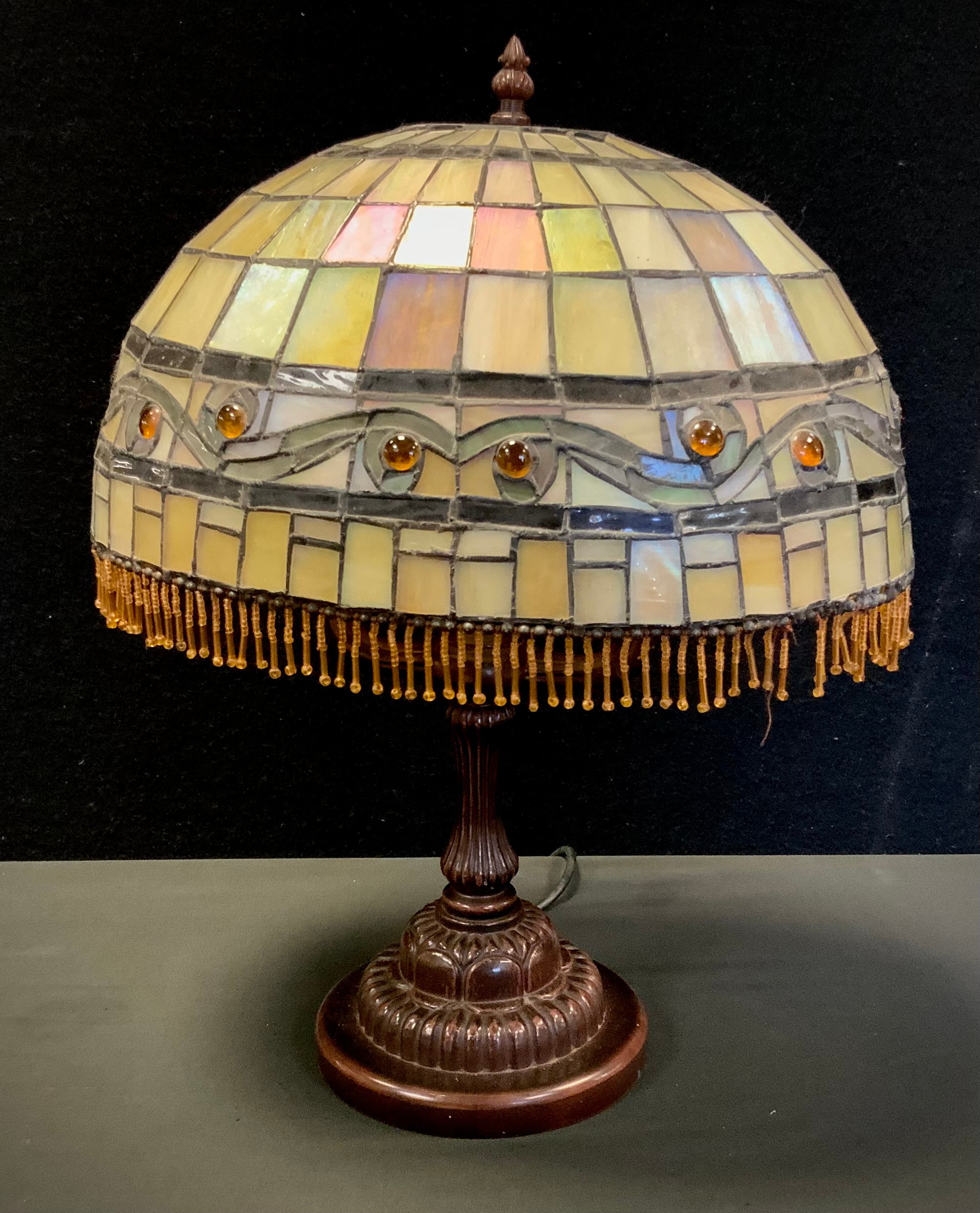 A Tiffany style oval stained and leaded glass table lamp, bronze coloured lamp base, the oval