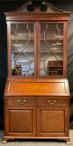 A Georgian style reproduction mahogany bureau bookcase, swan-neck pediment, dentil cornice, over a